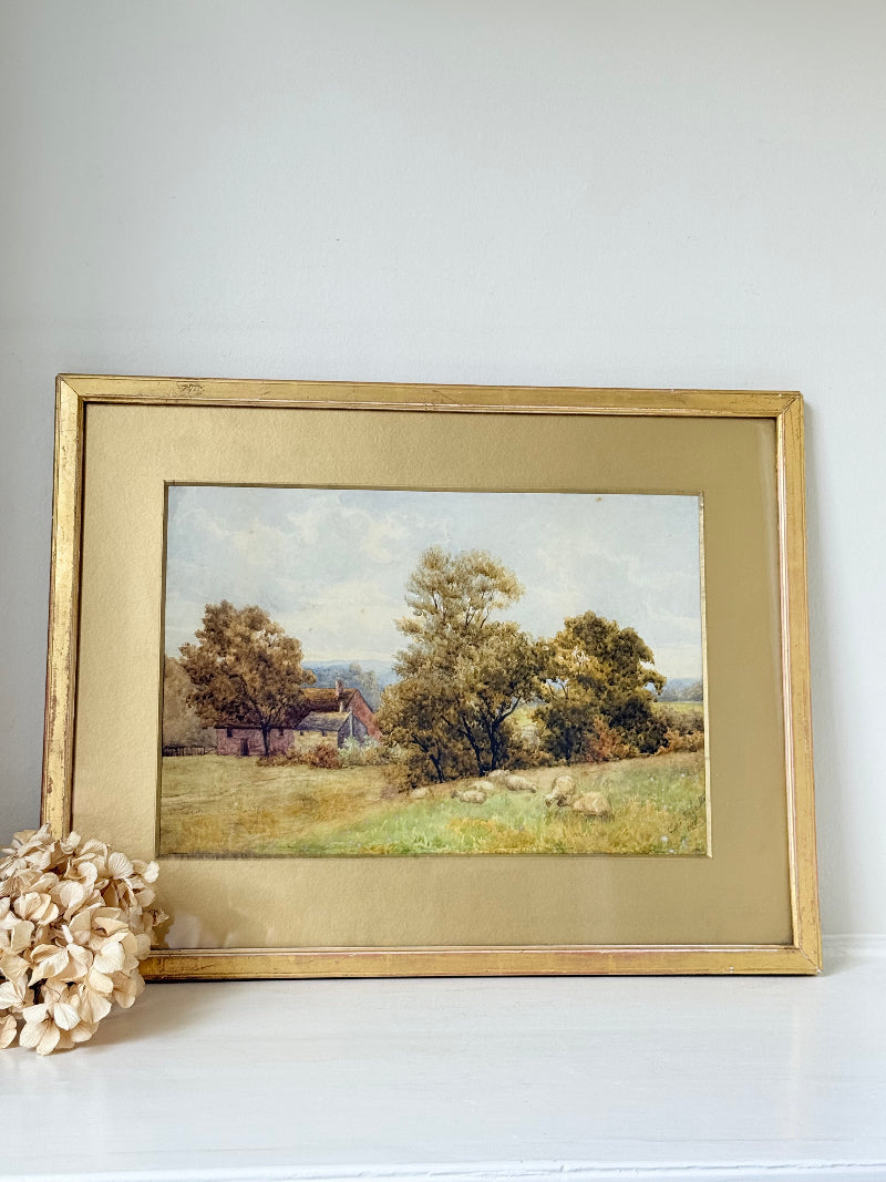 Antique watercolour landscape in gilt frame, countryside scene with trees, photographed on white surface.
