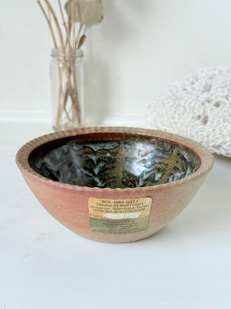 Benjamin Eeles studio pottery stoneware bowl with green and blue glazed interior on a white surface.