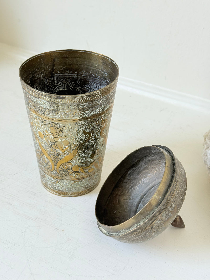 Indian Benares brass jar with lid and engraved animals and floral design, photographed on a white surface