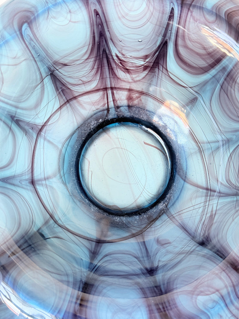 George Davidson blue cloud glass bowl with purple marbled swirls, photographed on a white surface