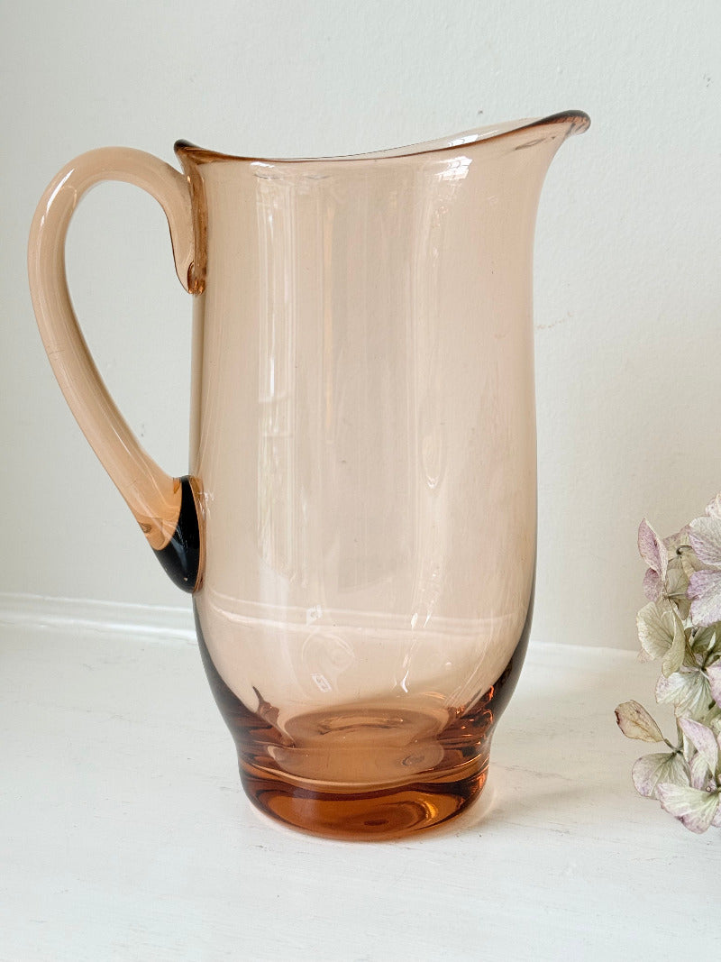 retro apricot glass serving jug with curved handle and flared spout, photographed on white surface