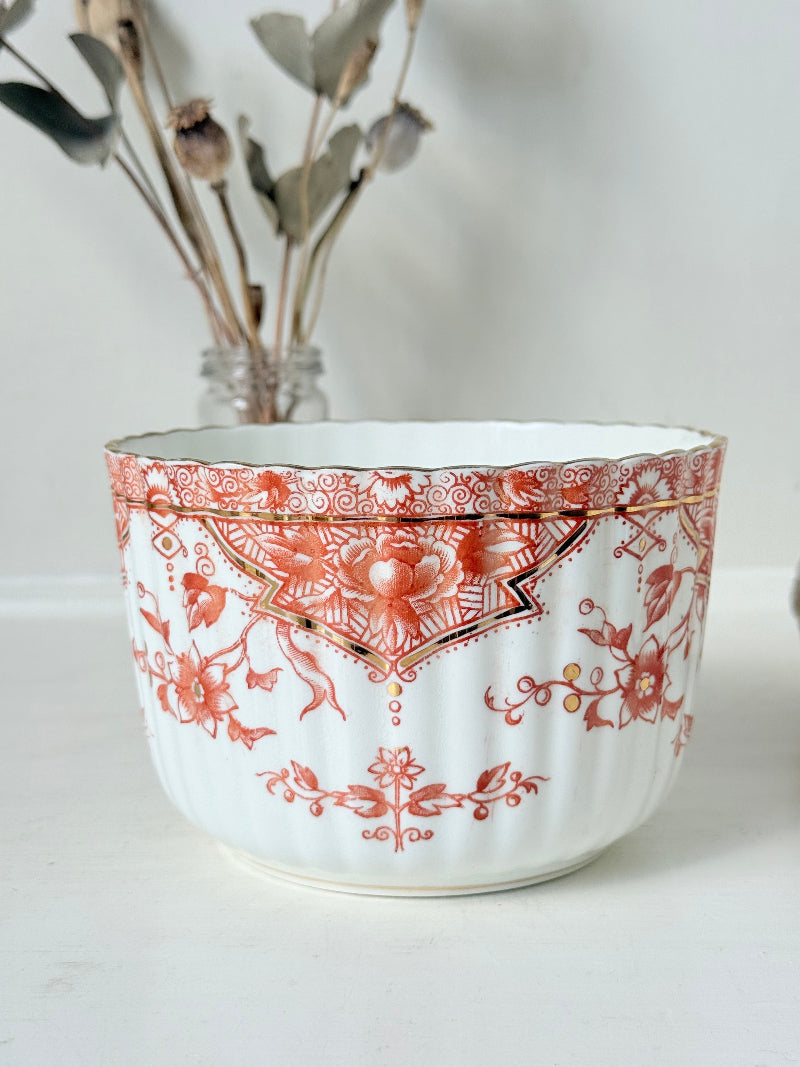 vintage porcelain sugar bowl with coral transfer design and gilt rim on white surface