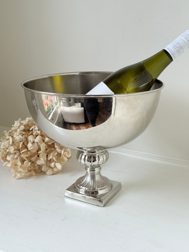 Vintage polished metal champagne bowl with pedestal base, photographed on a white surface