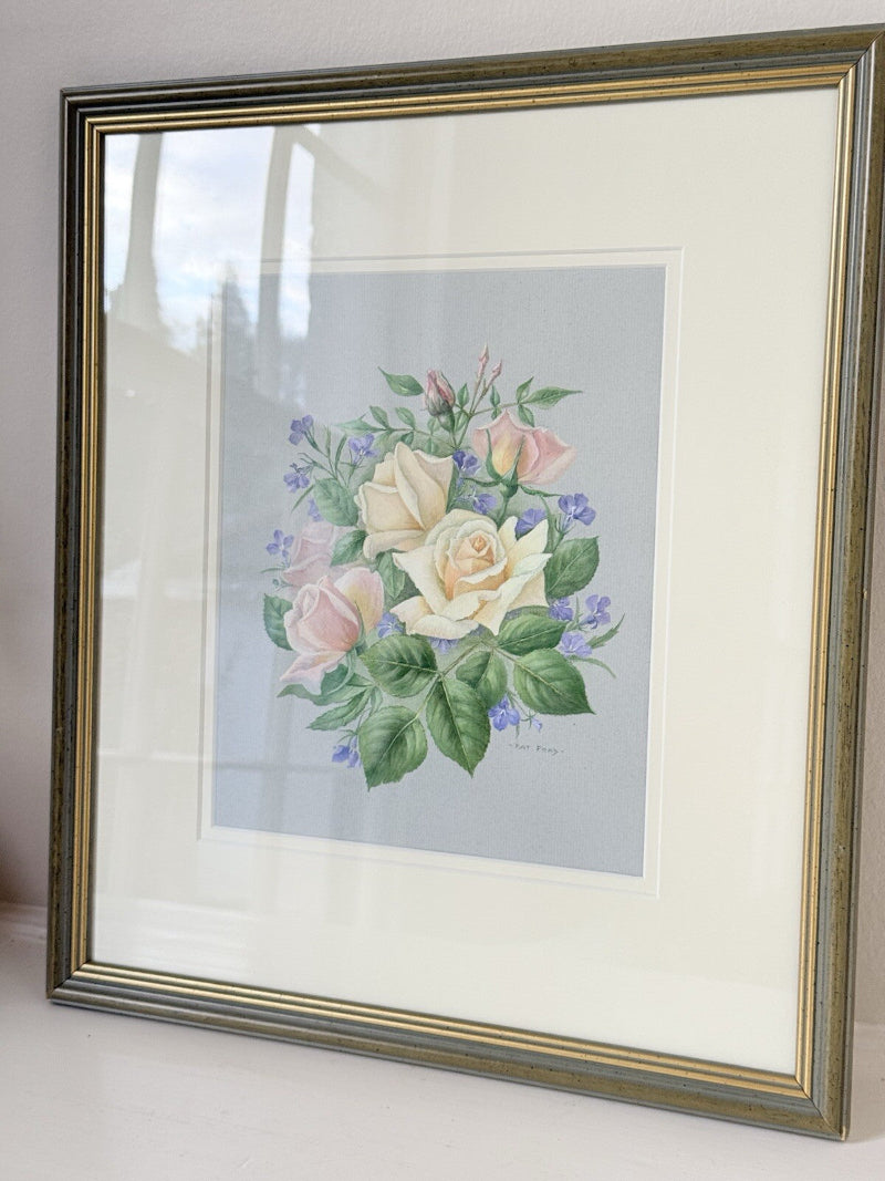Framed pencil drawing of pale yellow and blush roses with green leaves and purple flowers on a soft grey background, signed by artist Pam Ford.