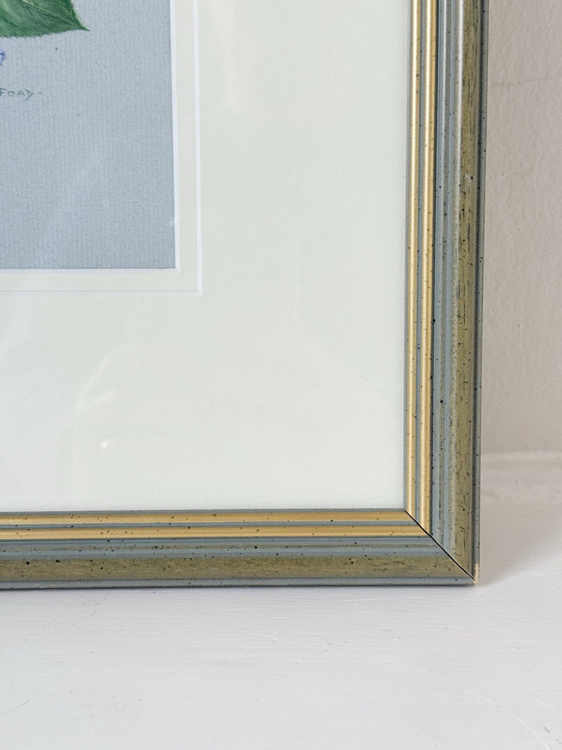 Framed pencil drawing of pale yellow and blush roses with green leaves and purple flowers on a soft grey background, signed by artist Pam Ford.