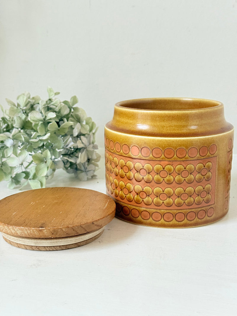 Vintage Hornsea kitchen canister in Saffron yellow with wooden lid photographed on a white surface.