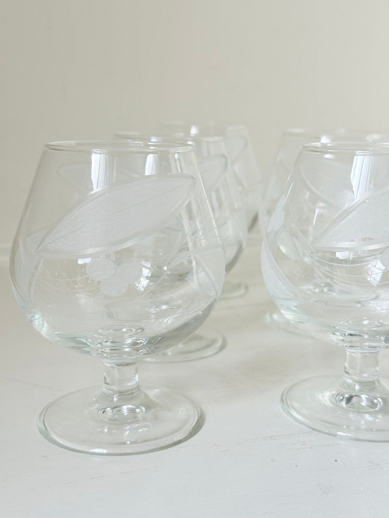 Set of six vintage etched Bailey’s glasses with rounded bowls and short stems, photographed on white surface.