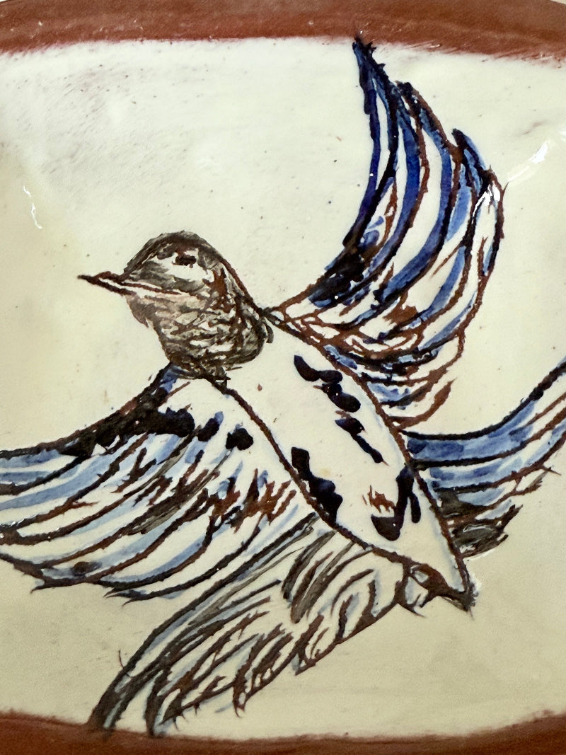 Vintage studio pottery soap dish with hand painted blue bird motif and terracotta rim, photographed on a white surface