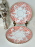 pair of vintage porcelain coral transfer plates with scalloped edges and gilt detail on white surface