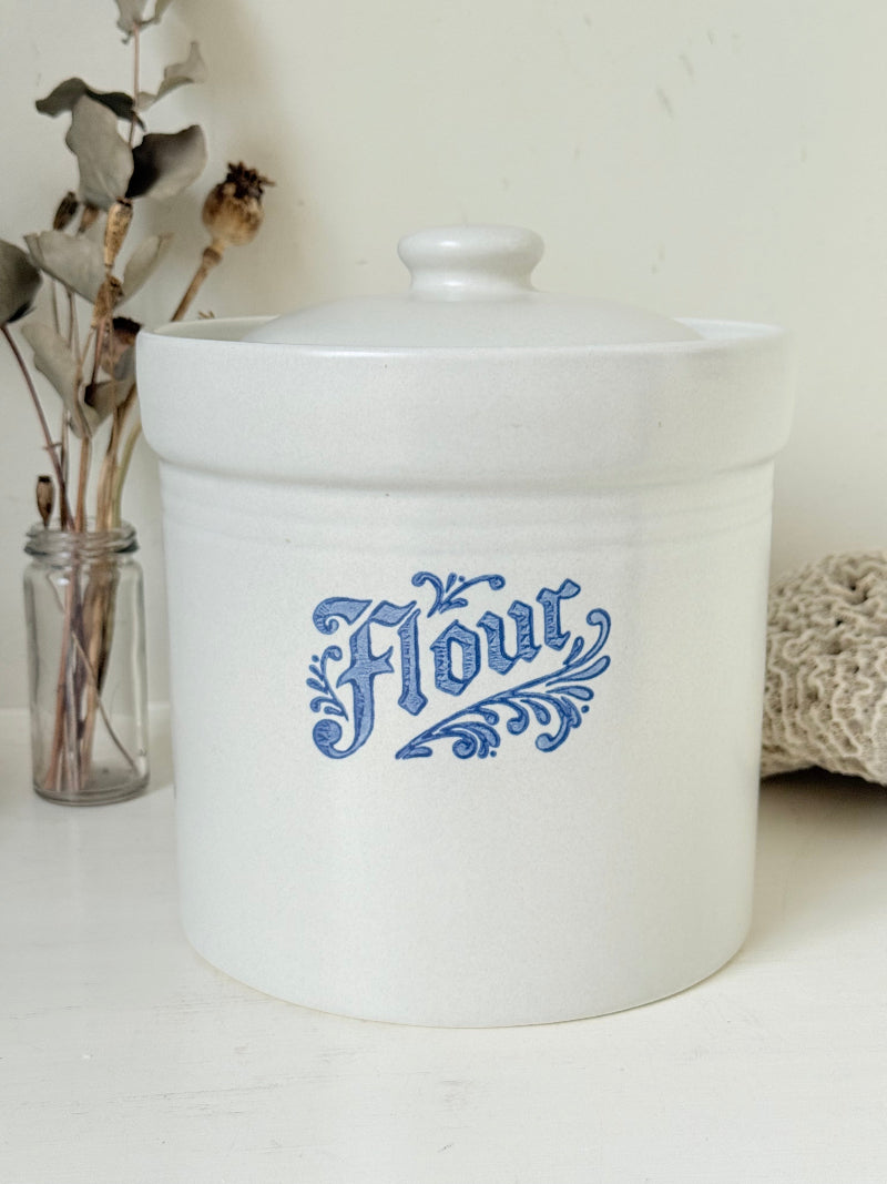 Pfaltzgraff Yorktowne stoneware flour pot with blue floral motif and lid, photographed on a white surface