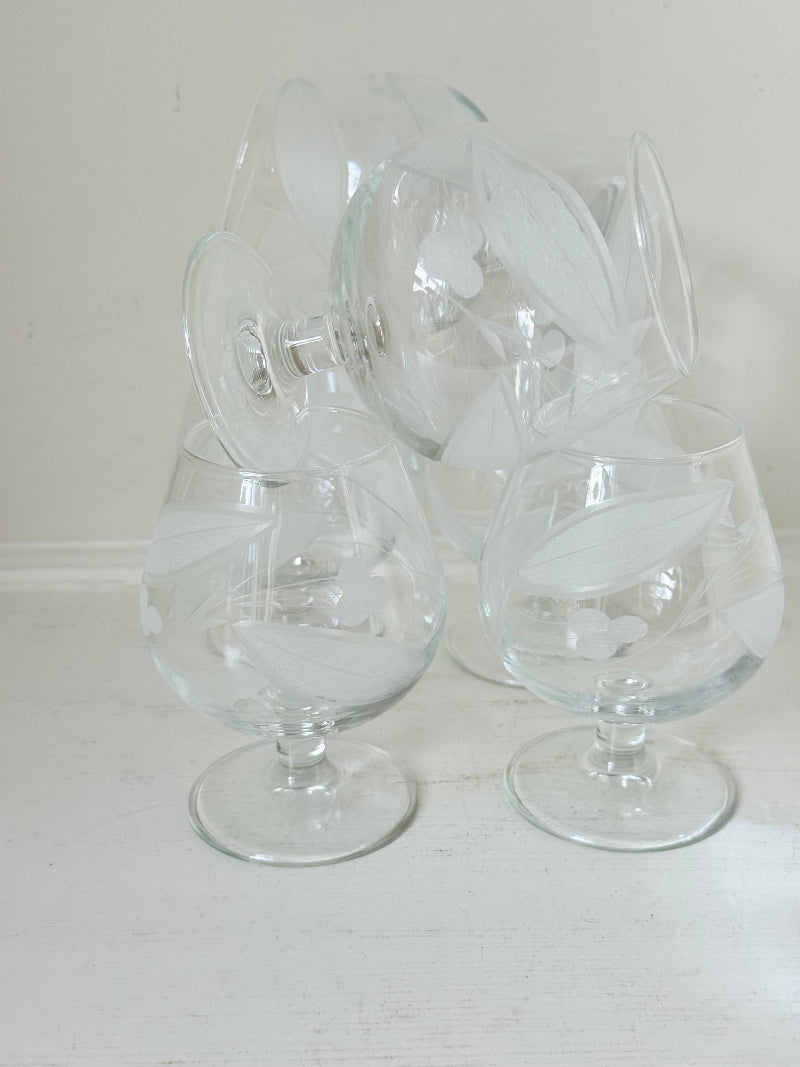 Set of six vintage etched Bailey’s glasses with rounded bowls and short stems, photographed on white surface.