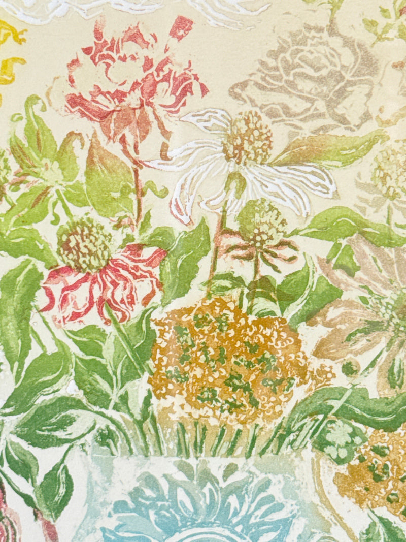 A close-up of a floral patterned surface featuring watercolor-style flowers in pink, white, yellow, and green on a light beige background.