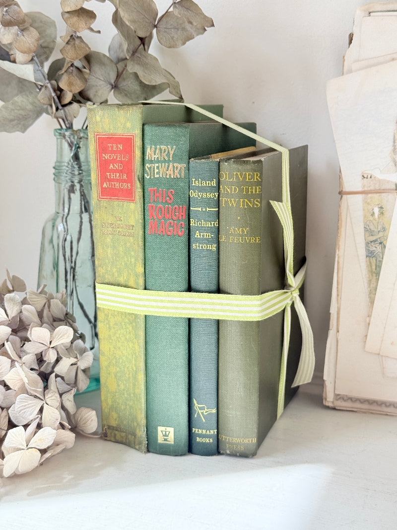 Bundle of vintage sage and olive green cloth books with red spine detail tied with a pale ribbon for styling