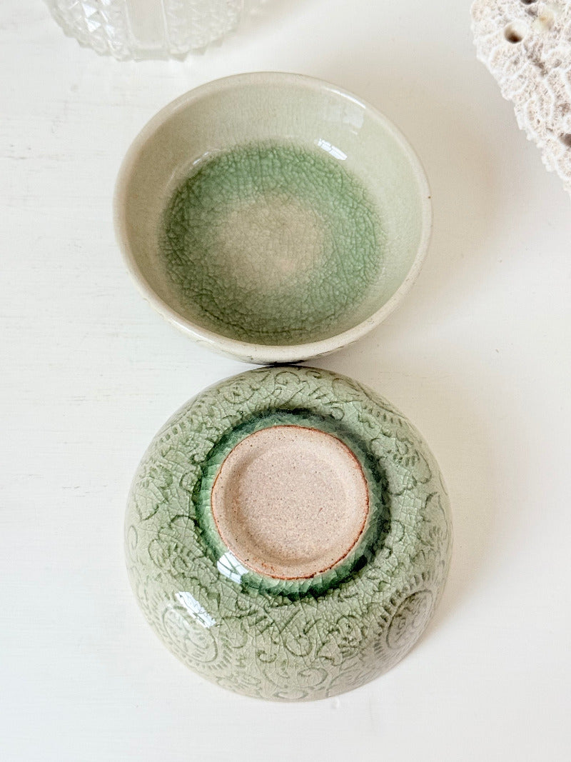 Pair of sage green Thai celadon olive bowls with crackled glaze, photographed on white surface
