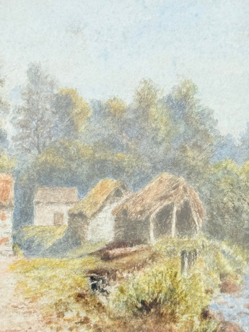 Framed vintage watercolour of countryside farm buildings with red roofs in gold frame photographed on a white surface