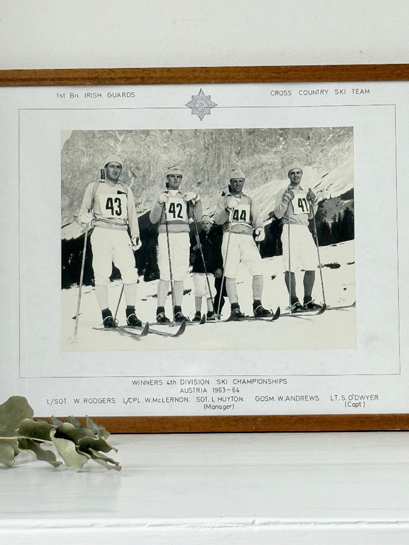 Vintage black and white framed photograph of the 1st Battalion Irish Guards Ski Team, 1963–64, posed in full ski gear against the Austrian Alps.
