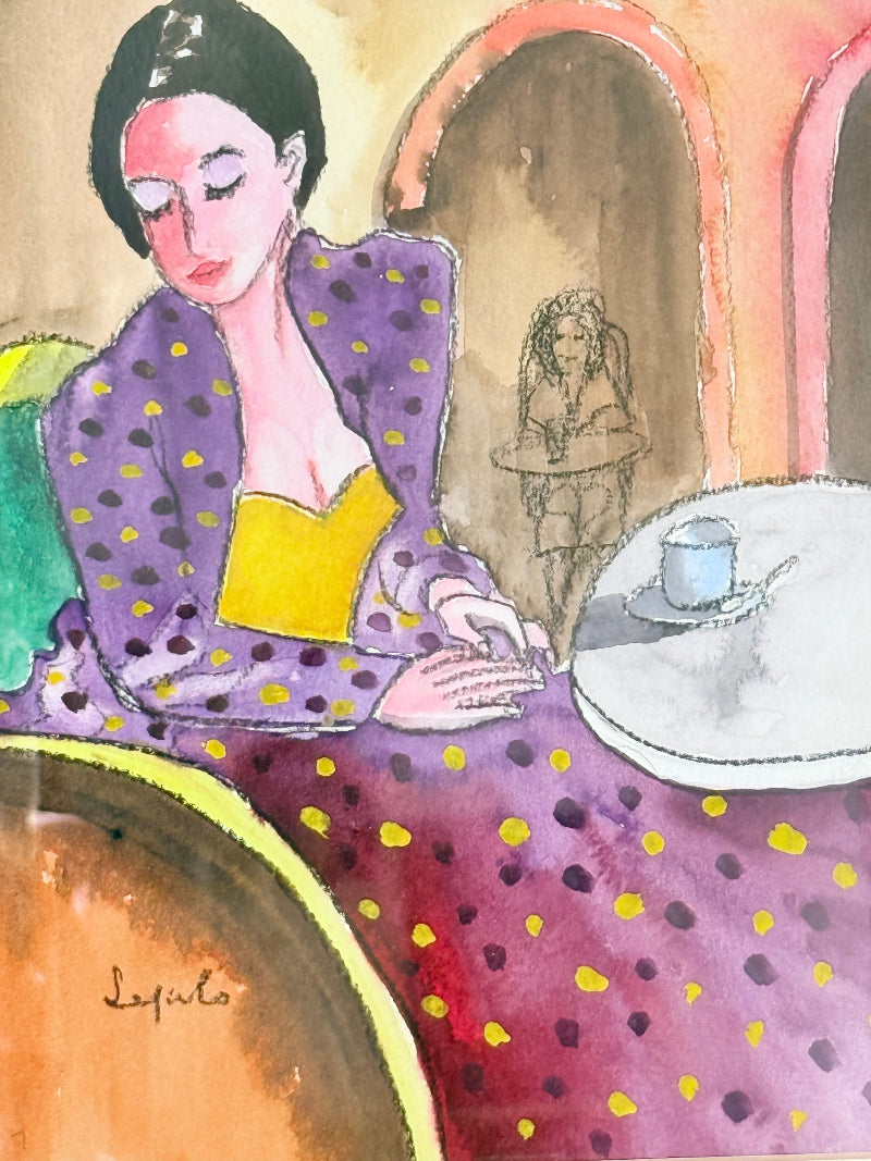 Original watercolour portrait of Pamela in blue frame, vibrant interior scene, photographed on white surface