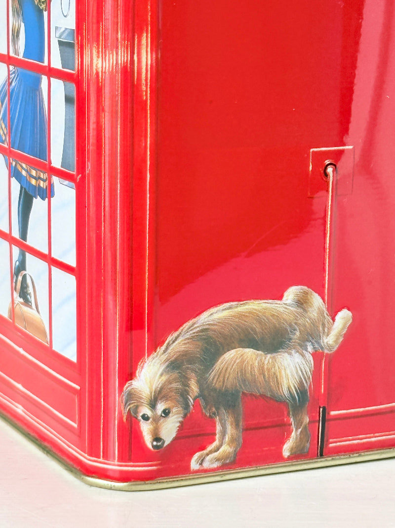 Vintage red telephone box tin money box on a white surface