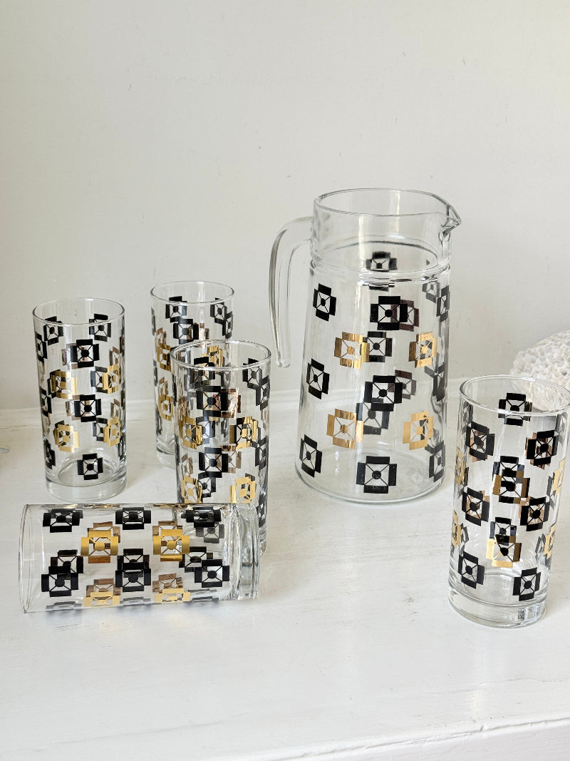 Mid century black and gold glass drinks set with jug and five highball tumblers in a geometric medallion pattern