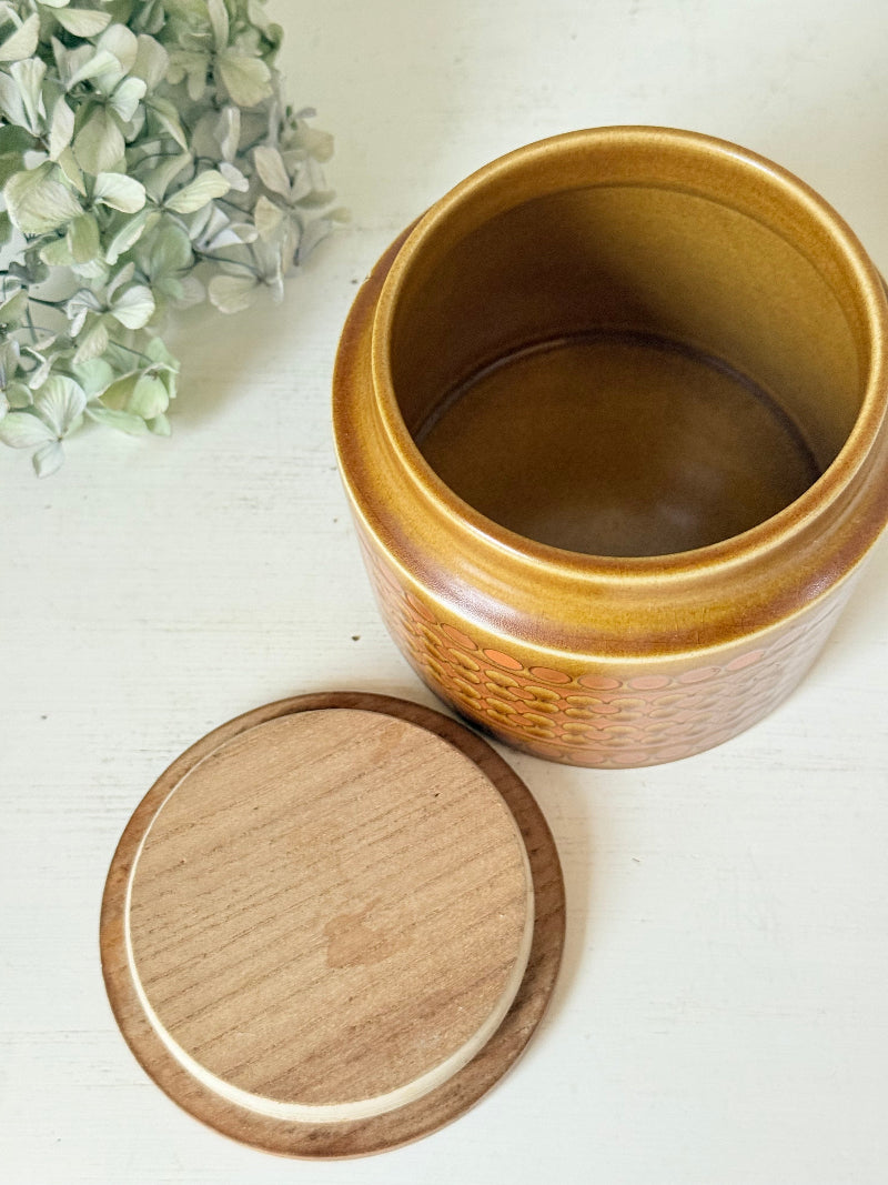 Vintage Hornsea kitchen canister in Saffron yellow with wooden lid photographed on a white surface.
