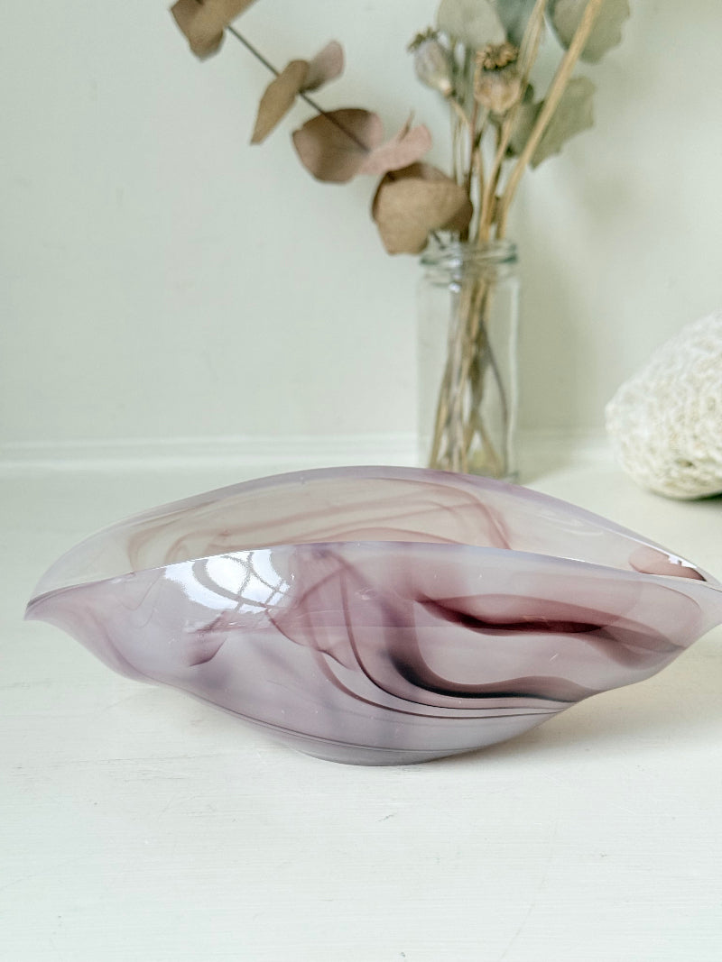 Vintage clam shaped Sowerby glass bowl in lilac purple swirl photographed on a white surface