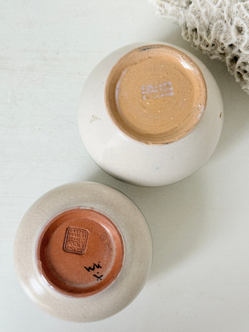 Pair of vintage studio pottery pots in blue green and pink glaze photographed on a white surface