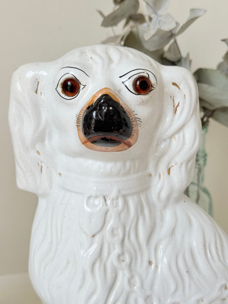 Near pair of antique white Staffordshire spaniel mantel dogs with glass eyes and worn gilt collars