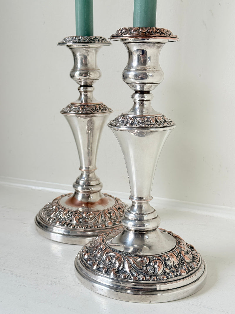 Pair of convertible silver plate on copper candelabra with repoussé detail, removable arms and green taper candles
