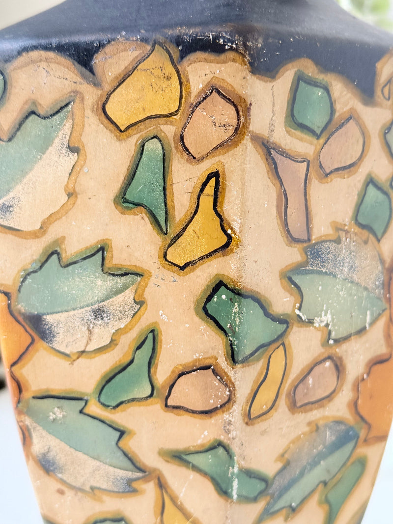 Art Deco Brentleigh Ware vase with hand painted floral design in orange, yellow, and teal on a black ground, photographed on a white surface
