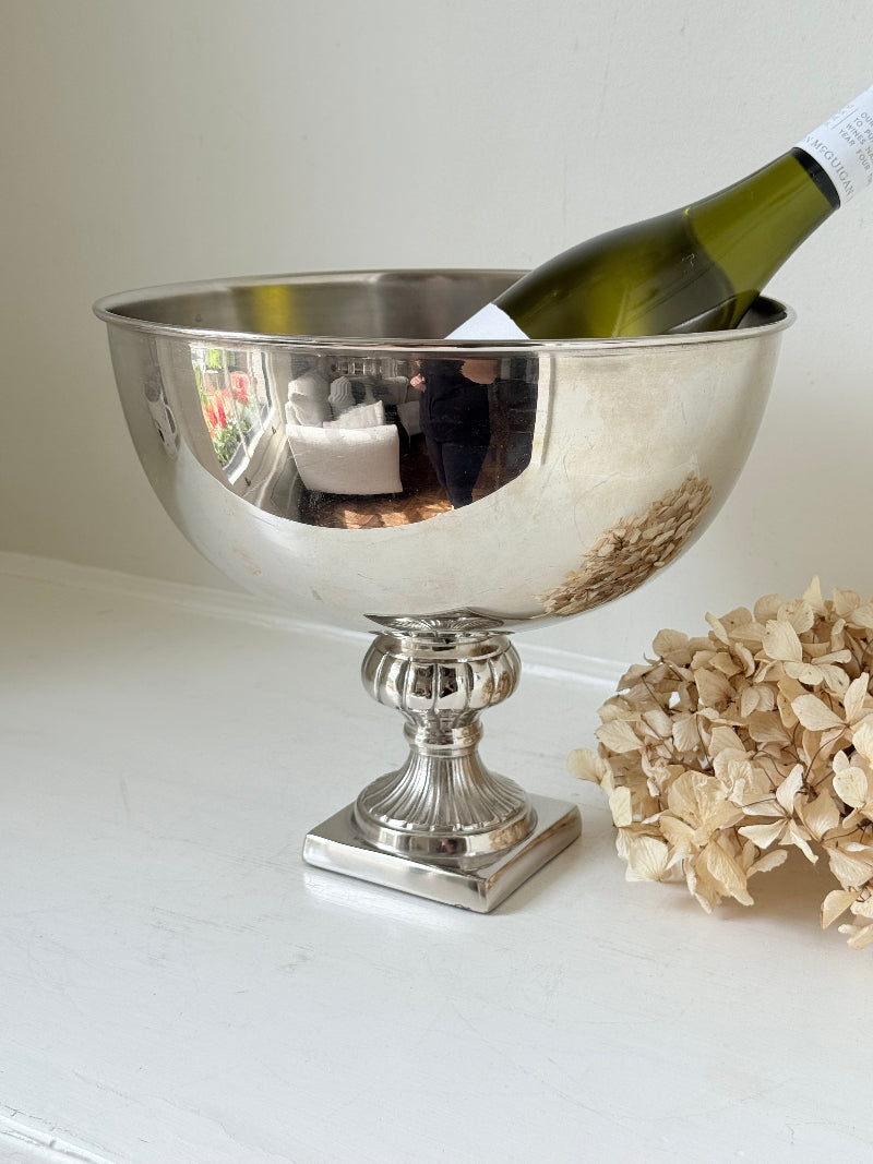 Vintage polished metal champagne bowl with pedestal base, photographed on a white surface