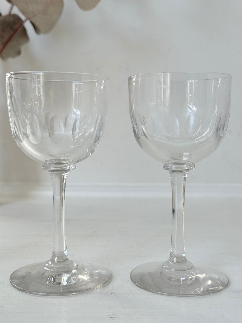 Set of 5 vintage clear glass liqueur glasses with small stems photographed on a white surface