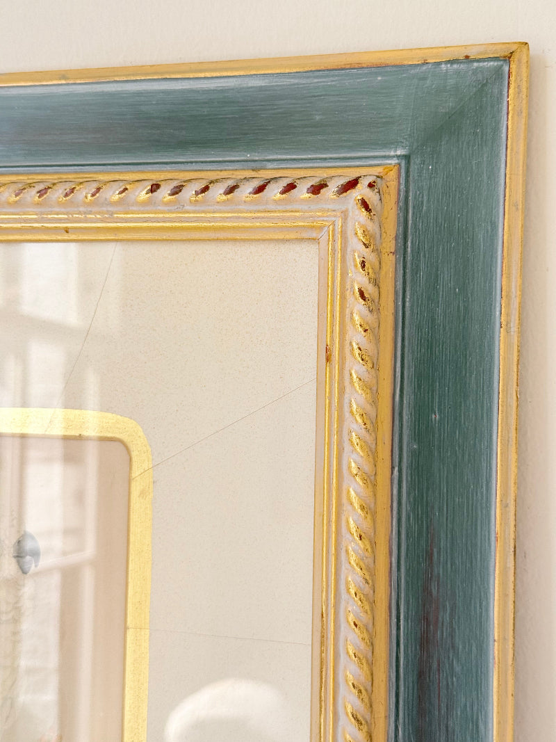 Framed cockatoo bird print in green and gold frame with mount, styled on white surface with vintage books