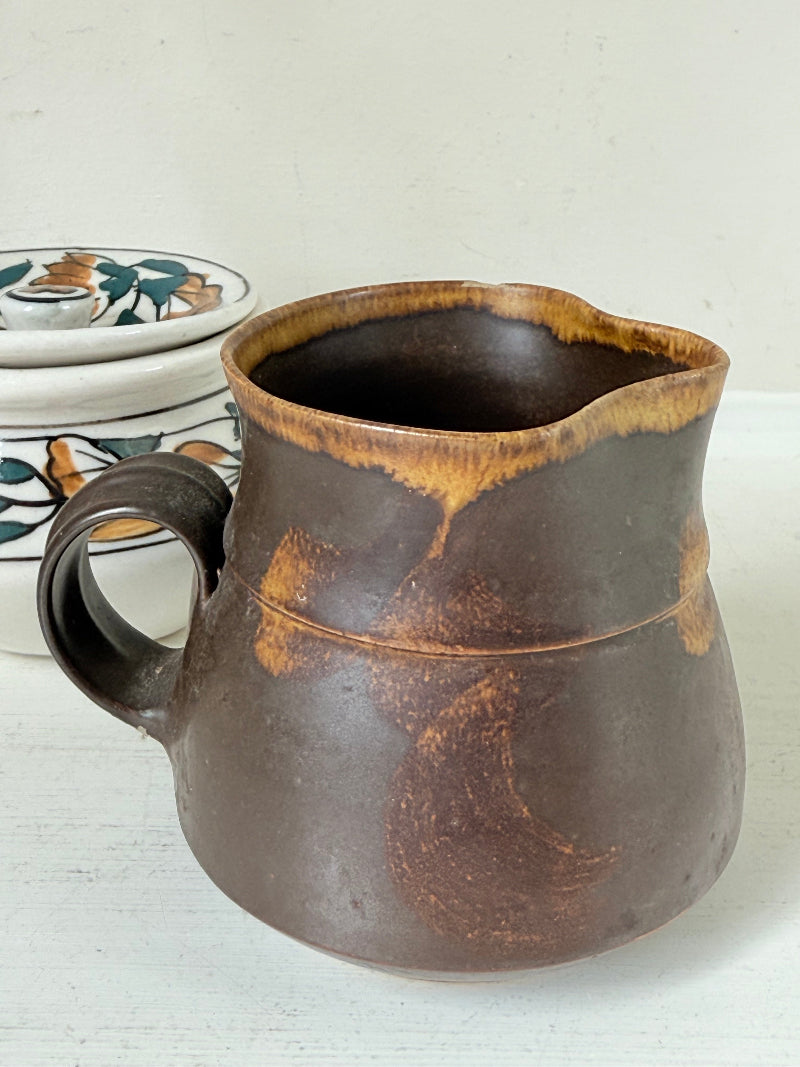 Studio pottery creamer and hand painted sugar bowl set, photographed on a white surface