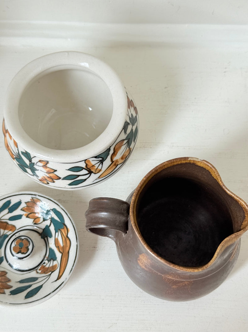 Studio pottery creamer and hand painted sugar bowl set, photographed on a white surface