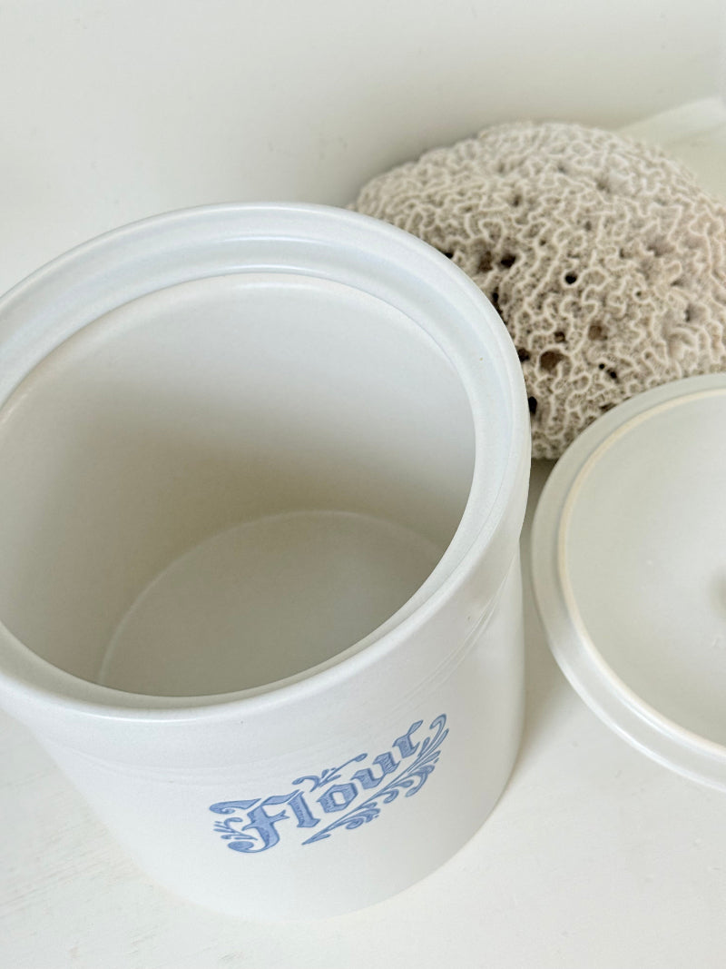 Pfaltzgraff Yorktowne stoneware flour pot with blue floral motif and lid, photographed on a white surface