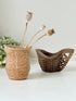 Pair of hand carved wooden jug and vase in contrasting light and dark tones, styled with dried poppy heads on a white surface.
