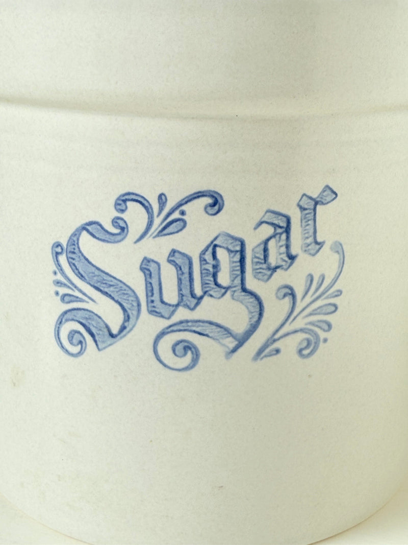 Pfaltzgraff Yorktowne stoneware sugar jar with blue floral motif and lid, photographed on a white surface