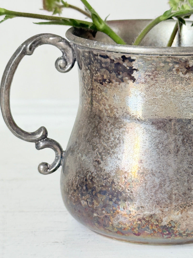 vintage silver plate beaker by arthur price with ornate handle and patina, photographed with red flowers on a white surface