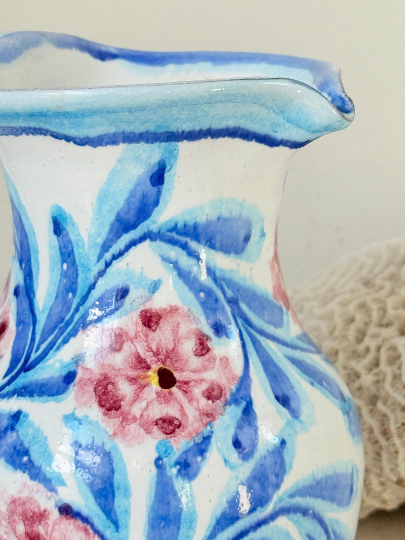 Portuguese studio pottery jug with blue and pink hand painted floral design, photographed on a white surface