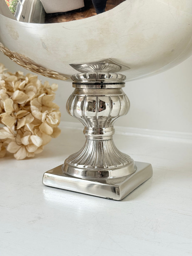 Vintage polished metal champagne bowl with pedestal base, photographed on a white surface