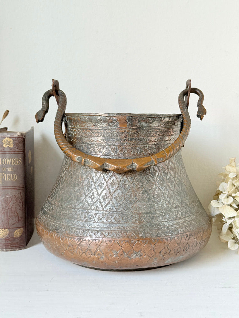 antique Middle Eastern water ewer with engraved diamond and foliate pattern and copper base, displayed on white surface