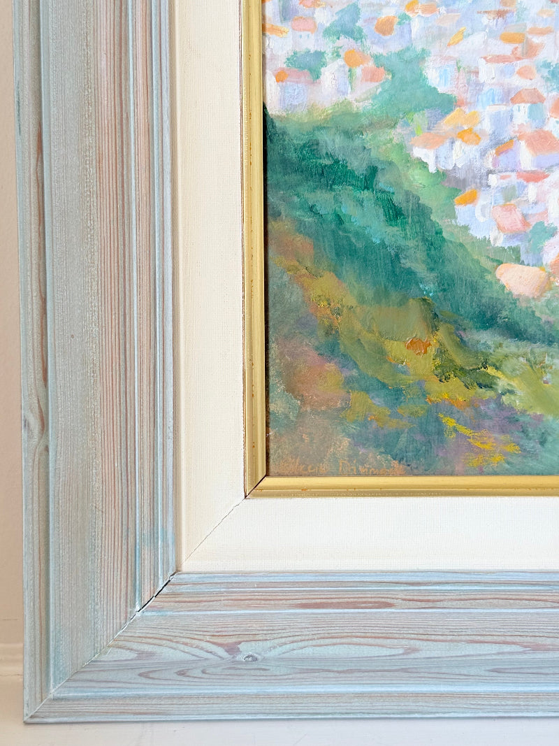 Framed oil painting of Costa del Sol with whitewashed hillside towns, photographed on a white surface
