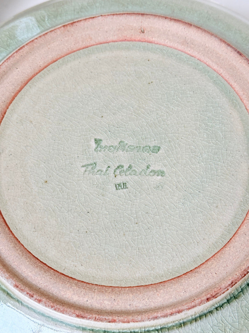 Set of four large Thai celadon stoneware plates in soft green glaze with raised pattern, photographed on a white surface