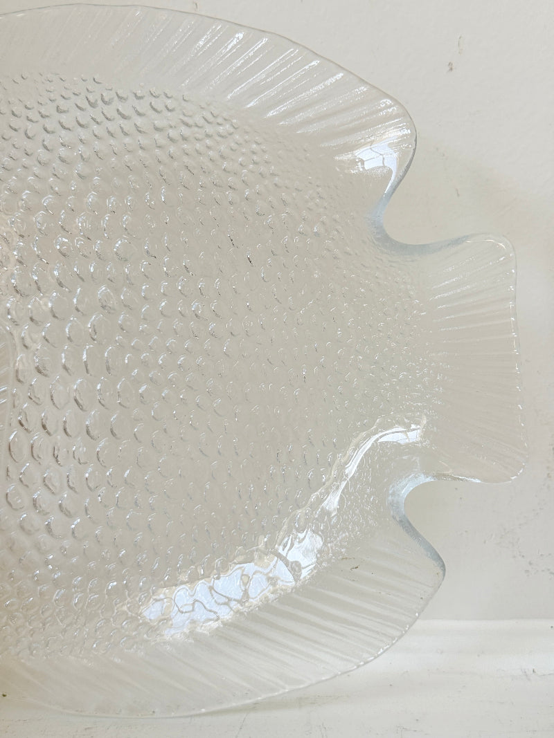 Vintage clear glass fish shaped serving dish with textured scale pattern photographed on a white surface