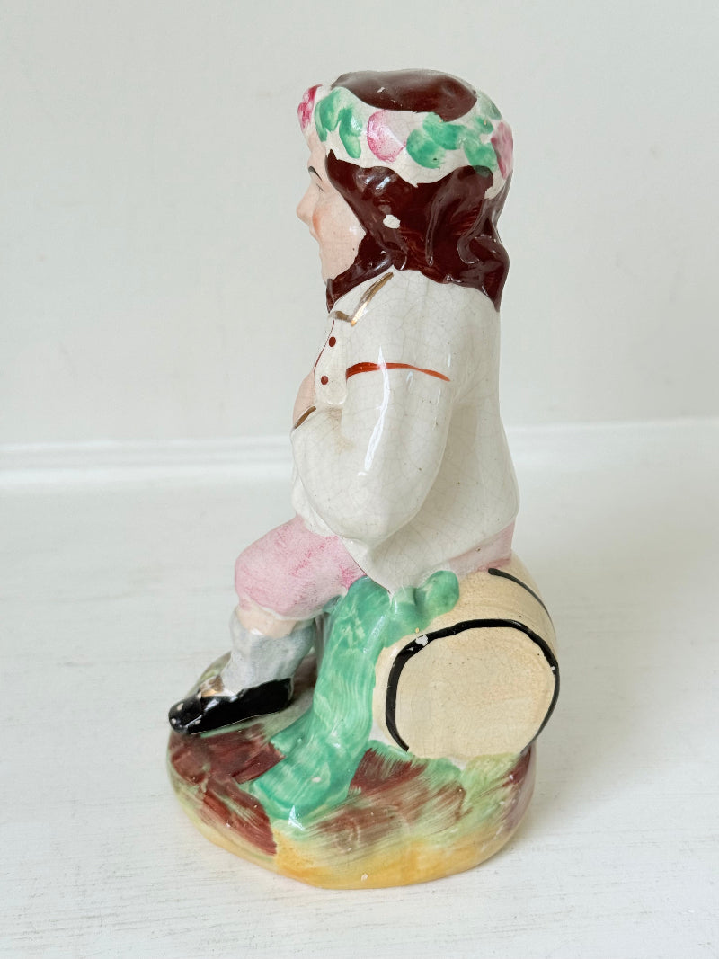 Bacchus antique Staffordshire pottery figure with painted details, photographed on a white surface.