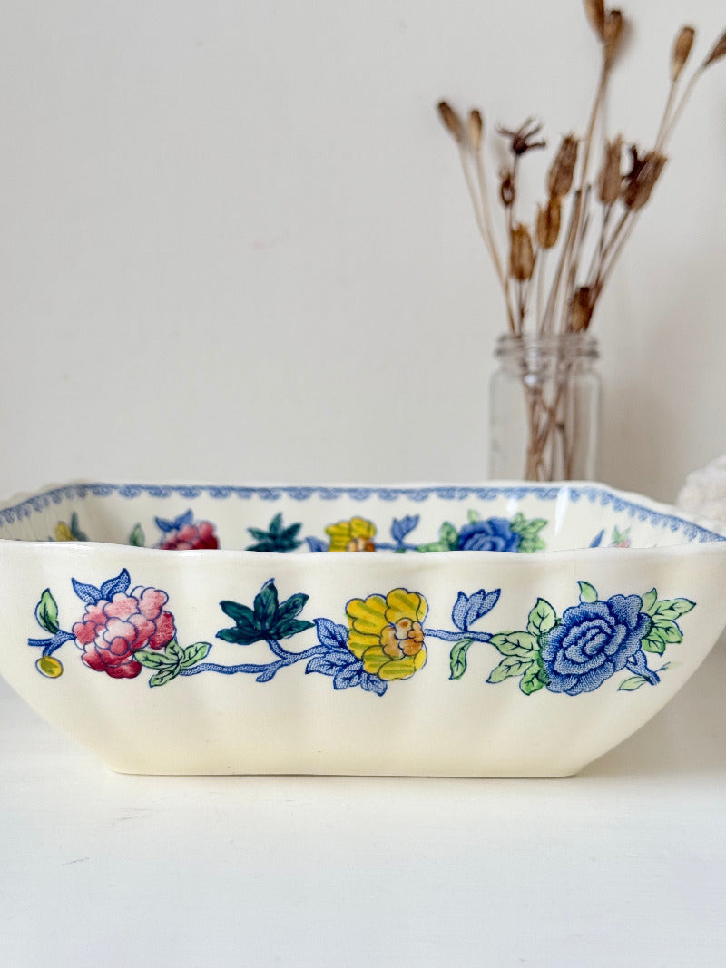 Vintage Mason’s ironstone serving dish with square form and spring floral pattern in blue, pink, yellow, and green, photographed on a white surface