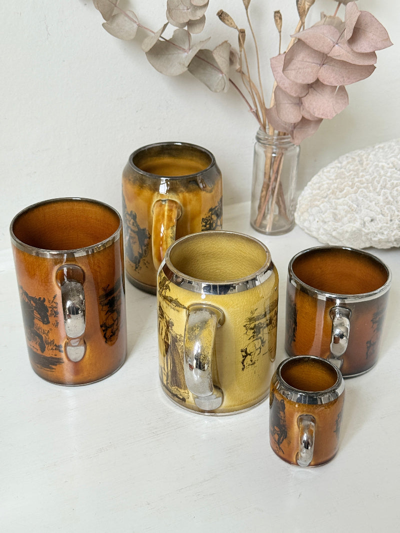 Set of 5 Ridgways stoneware mugs photographed on a white surface in amber brown glaze with black Coaching Days and Coaching Ways transfer scenes