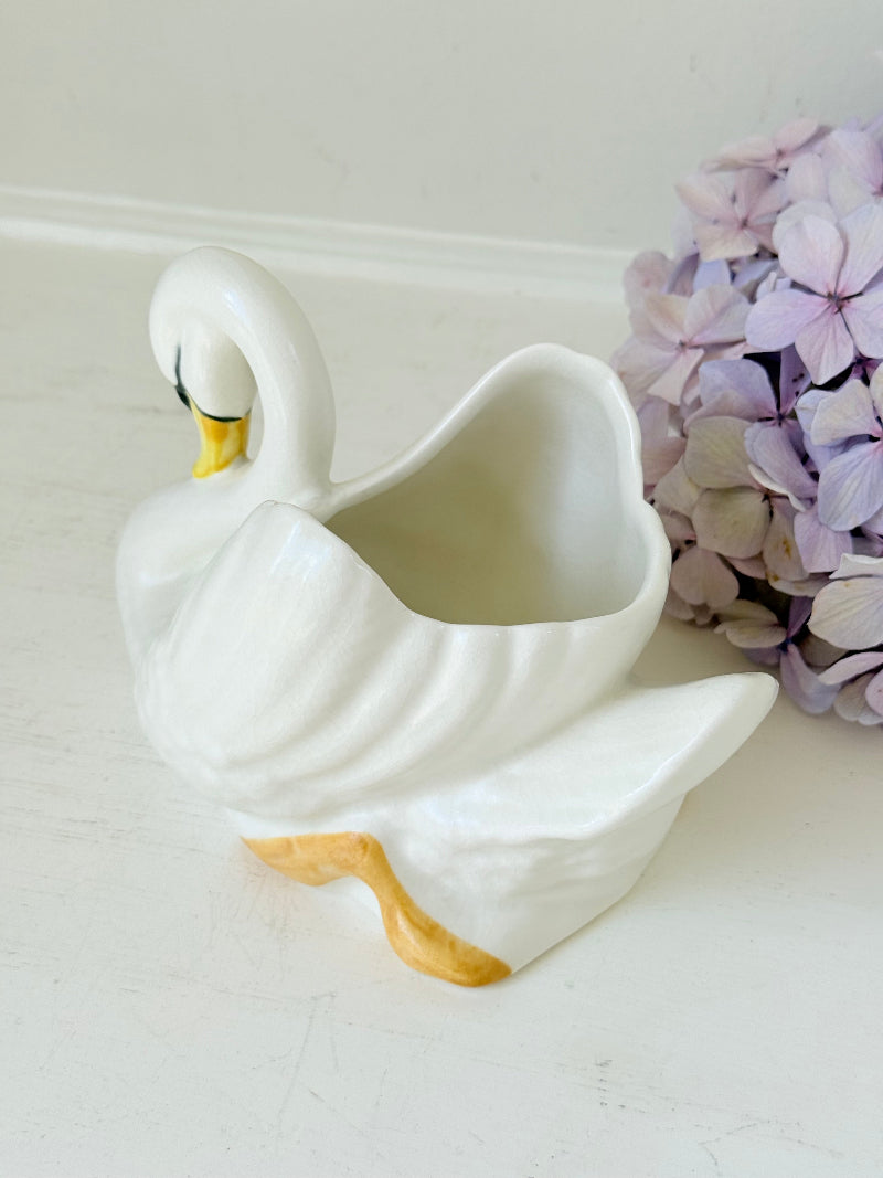 Vintage Sylvac swan planter in white ceramic with yellow beak and feet, styled on a white surface