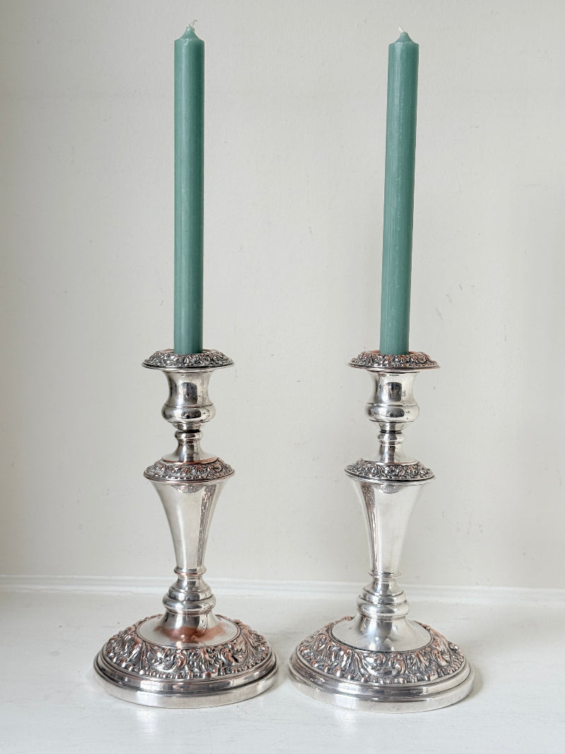 Pair of convertible silver plate on copper candelabra with repoussé detail, removable arms and green taper candles