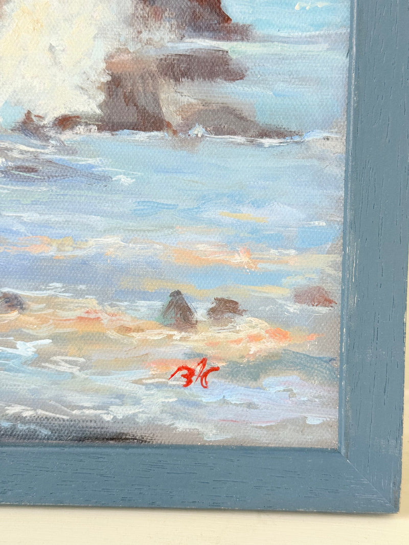 Original oil painting of waves crashing against rocks, signed seascape in slate blue wooden frame on white surface